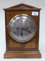 An Edwardian oak cased mantel clock; the 8 day movement faced by a silvered Arabic dial  14"h