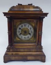 An early 20thC walnut veneered cased bracket clock with brass mounts and a folding top handle; the