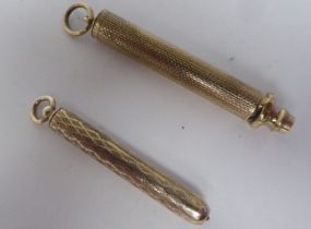 Two similar yellow metal cased propelling pencils, on pendant rings