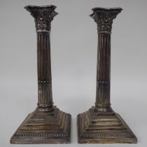 A pair of loaded silver Corinthian column candlesticks with detachable, bead bordered sconces and
