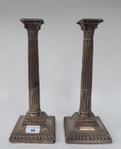 A pair of late Victorian loaded silver candlesticks with Corinthian capitals and detachable sconces,