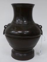 An early 20thC Japanese patinated bronze vase of waisted, bulbous form with opposing ring handles