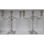 A pair of Georgian style, two-part silver candelabra, each comprising a central socket and two