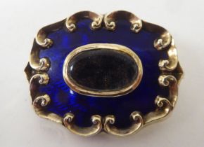 A Victorian (probably 15ct) gold and midnight blue enamel mourning brooch, in a C-scrolled frame