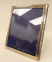 A glazed silver photograph framed, on a blue fabric back and easel stand  RC  London 1977  11.5" x