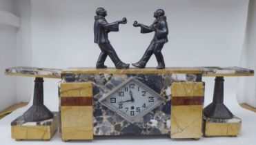 An Art Deco marble three piece garniture, the clock surmounted by two clowns, playing bowls; the