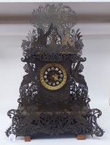 A Continental fretworked brass cased mantel clock, featuring nude term figures, heraldic lions,
