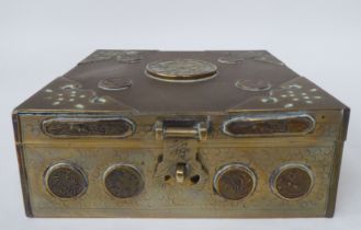 A Chinese brass casket with engraved decoration, mounts, applied medallions and a carved jade tablet