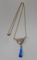 An Art Deco design gold coloured metal necklace, set with a cabochon pearl and blue stone pendant,