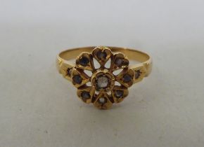 A yellow metal floral design, diamond set ring