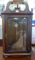 A reproduction of a 19thC mahogany finished corner cupboard with a scrolled pediment and single door