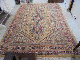 A Tabriz style carpet with three central motifs, bordered by repeating stylised designs, on a