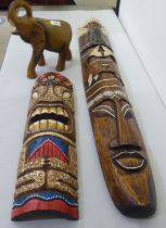 Two modern painted wooden tribal inspired masks  39" & 20"h; and a carved softwood model elephant