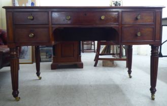 A late Victorian mahogany kneehole five drawer writing table with a low part gallery border,