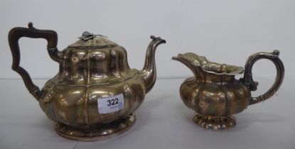 A late 19thC Continental white metal teapot and milk jug of pedestal, ribbed design