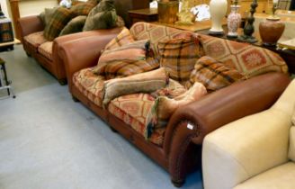 A matched pair of modern two person settees with low, level backs and scrolled arms, part stud
