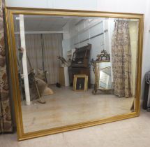 A modern mirror, the bevelled plate set in a moulded and silvered gilt frame  66" x 77"