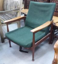 A 1970s teak framed open arm chair with semi-reclining action, raised on turned legs