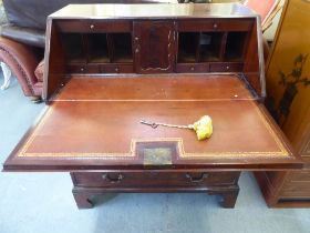 A George III mahogany bureau, the fall-flap over four graduated drawers, raised on bracket feet