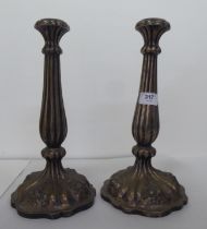 A pair of late 19thC Continental white metal candlesticks, each with a reeded column, on a