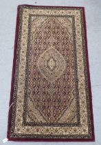 A modern Persian woollen rug, decorated in colours  59" x 31"