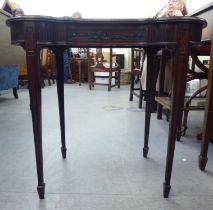 An Edwardian mahogany kidney shape occasional table with a carved apron, raised on square, tapered