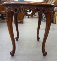A modern mahogany finished occasional table with a carved frieze, raised on cabriole legs and