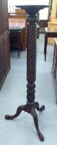 A Victorian style mahogany torchere with a turned plate top, over a wrythen carved column, raised on