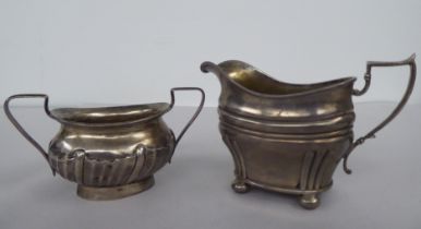 An Edwardian silver oval cream jug, on bun feet  London 1905; and a contemporary silver twin handled