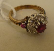 A bi-coloured metal ruby and diamond cluster ring  stamped 18k