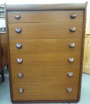 A 1970s teak tallboy, comprising six graduated long drawers with grab handles  42"h  30"w; and a