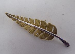 An 18ct bi-coloured gold leaf design brooch, set with a diamond