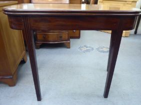 A late Georgian mahogany D-shape tea table with a foldover top, raised on reed moulded, tapered