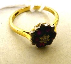 A bi-coloured metal ruby and diamond cluster ring  stamped 18k