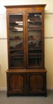 A late Victorian mahogany cabinet bookcase with a straight cornice, over a pair of full-height,