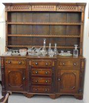 A George III mahogany inlaid oak breakfront dresser with a three tier plate rack, over six drawers
