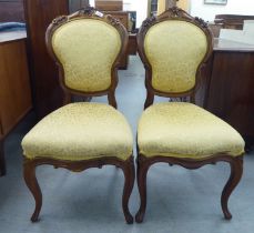 A pair of Edwardian carved hardwood framed salon chairs with shield shape backs and braided old gold