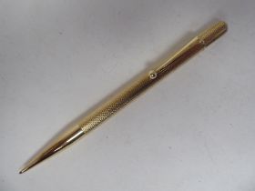A 9ct gold propelling pencil with engine turned decoration