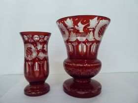 Two late 19thC cranberry coloured and clear glass vases with similarly engraved ornament  11" & 9"h