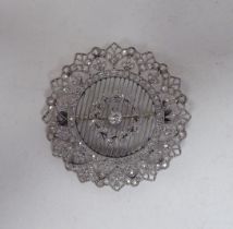 A white metal wire and filigree style diamond set, circular and foliate design brooch