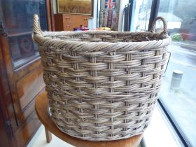 A woven cane twin handled log basket  18"h  27"dia