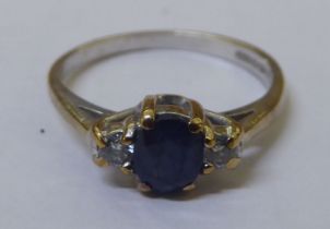 A 9ct white gold claw set sapphire ring, flanked by two diamonds