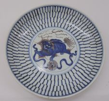 A 19thC Chinese provincial footed porcelain dish, decorated in blue, brown and white with a dragon-