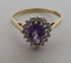 A 9ct gold cluster ring, the pear cut purple stone, surrounded by diamonds