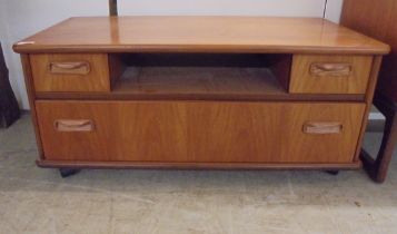 A G-Plan teak television stand with an open shelf and three drawers, on a plinth and castors  16"