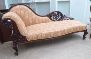 A mid Victorian walnut carved and showwood framed chaise lounge, later upholstered in floral