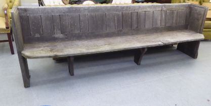 A 19thC rustically constructed weathered pine church pew  96"w