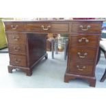 An early/mid 20thC mahogany eight drawer twin pedestal desk, raised on bracket feet  29"h  48"w