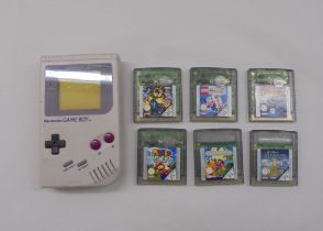 A Nintendo Game Boy and six game cartridges (no paper labels)