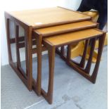 A nesting set of three 1970s G-Plan teak tables, designed by R Bennett, raised on open